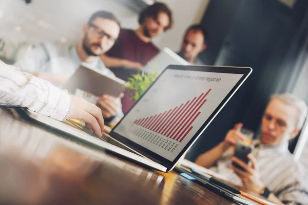 Jonge vrouw financieel analist kijkt naar bedrijf jaarverslag. Grafiek of diagram op het scherm van de laptop. Teamwork van managers op een nieuw project — Stockfoto