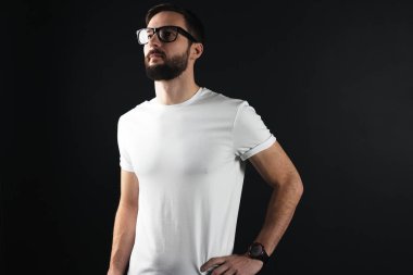 Acımasız ve kaslı adam koyu arka plan üzerinde beyaz boş gömlekli sakallı