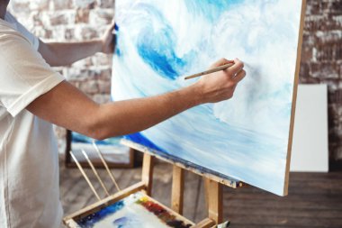 Çizim süreci üzerine yağlıboya sanat Studio sanatçı. Ressam tutun fırça el önünde resim