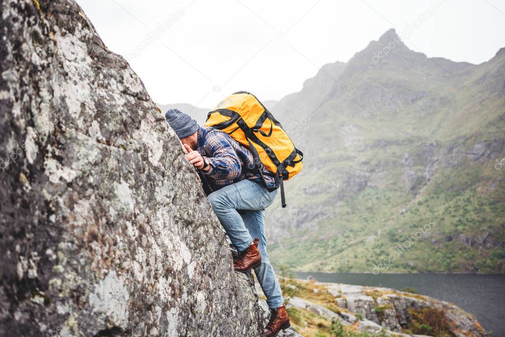 Brave lifestyle climber with professional backpack climb to the rock. Active fearless tourist swarm up on mountain 