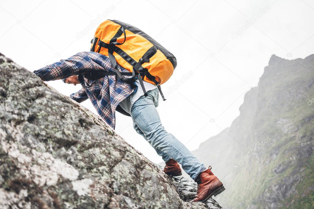 Young extreme lifestyle climber with professional backpack climb to the rock. Active fearless professional tourist swarm up on mountains