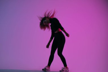 Renkli arka plana karşı stüdyoda poz veren yaratıcı bayan dansçı. Dans eden genç karizmatik kadın