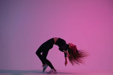 Renkli arka plana karşı stüdyoda poz veren yaratıcı bayan dansçı. Dans eden genç karizmatik kadın