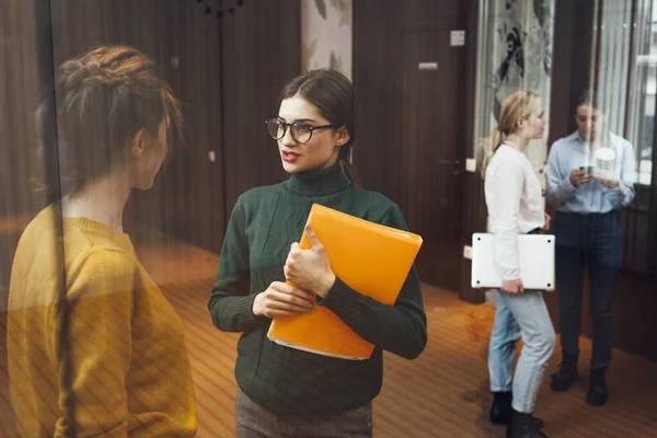 Group of positive female office employees have meeting at workplace at modern office. Business people discussing together working process