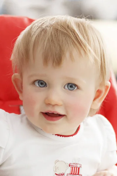 Portrait of a little girl with blue eyes who smiles and looks at the camera — Stock Photo, Image