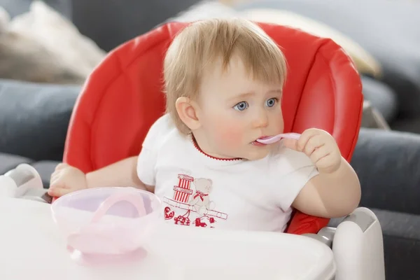 Kind met blauwe ogen, blonde zitten en eten van PAP — Stockfoto