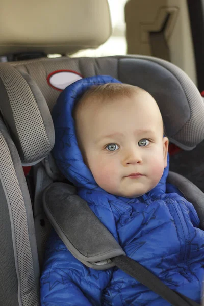 Portrait of cute toddler boy sitting in car seat. Child transportation safety — Stock Photo, Image