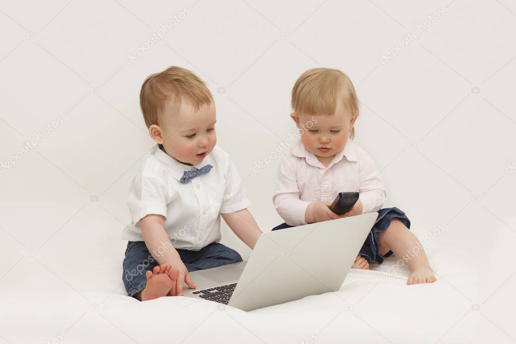 two small children sit in front of the computer