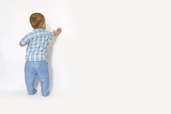 Egy kisfiú áll, a falnak — Stock Fotó
