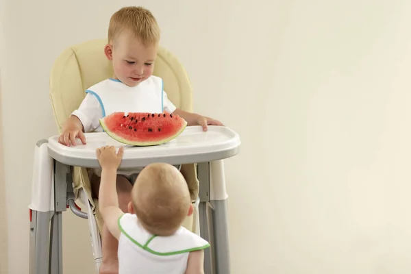 Два маленьких мальчика с светлыми волосами едят красный арбуз — стоковое фото