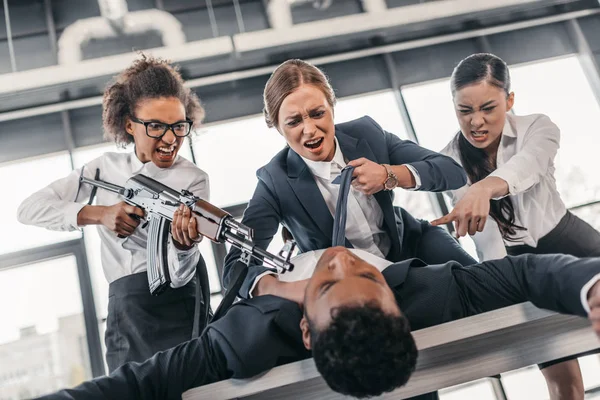 Businesswomen punishing businessman — Stock Photo, Image