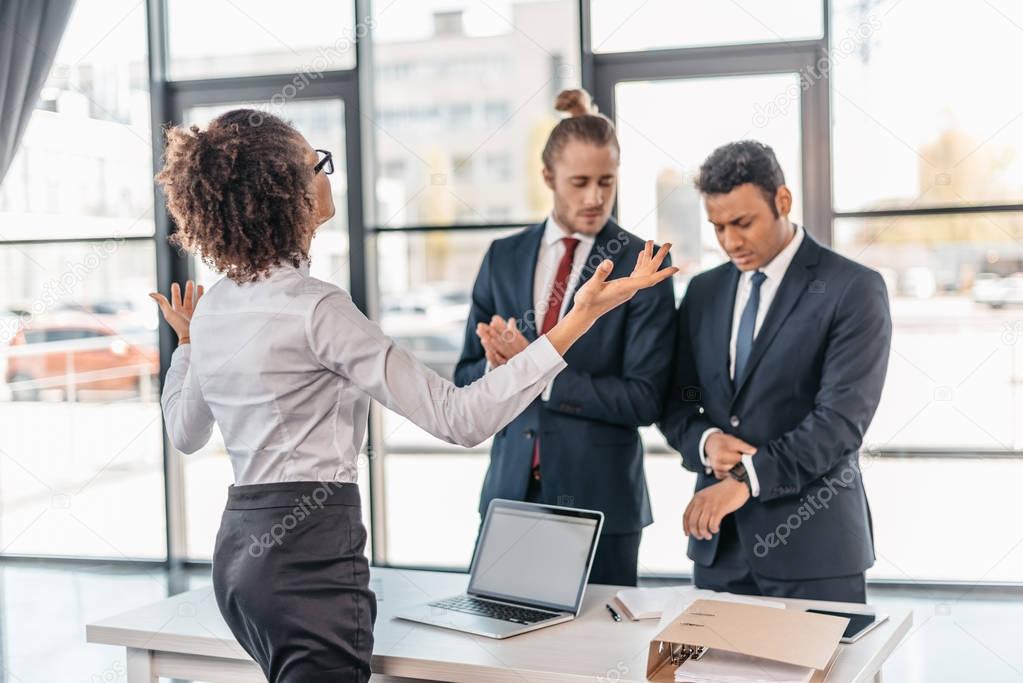 Businesswoman arguing with coworkers 