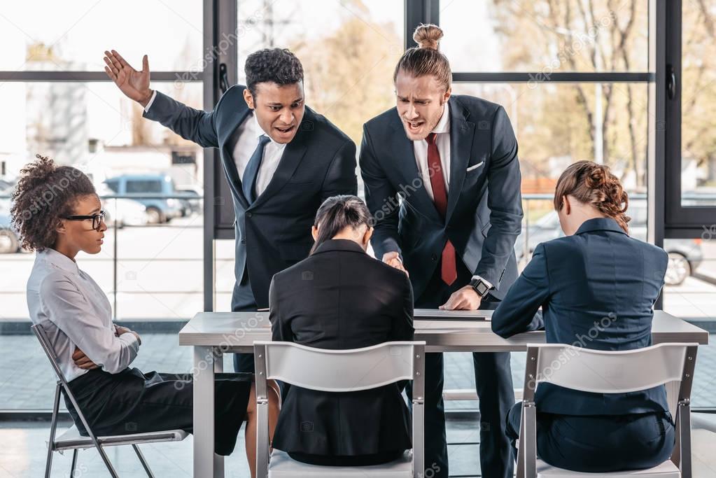 businesspeople arguing at meeting in office