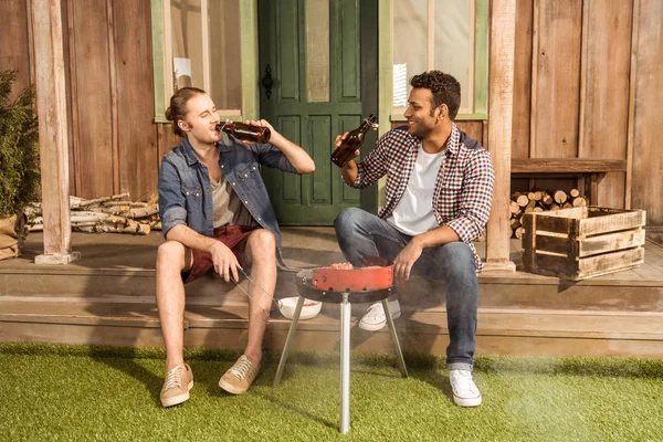 Young men grilling burgers — Stock Photo, Image