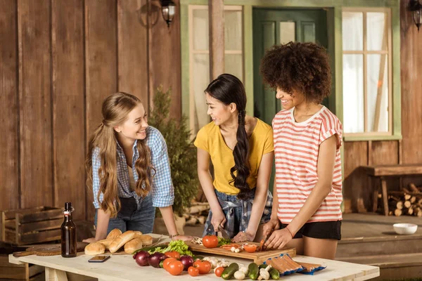 Jonge vrouwen snijden van groenten — Stockfoto