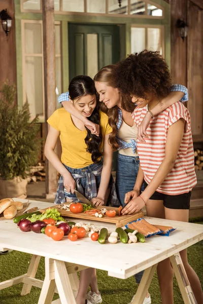 Jonge vrouwen snijden van groenten — Stockfoto
