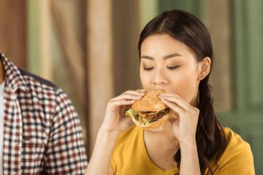burger yiyen genç Asyalı kız