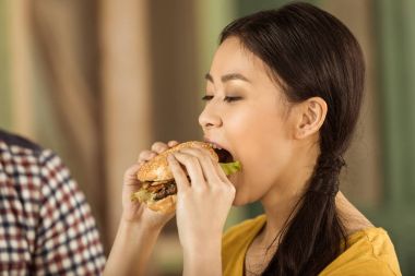 burger yiyen genç Asyalı kız