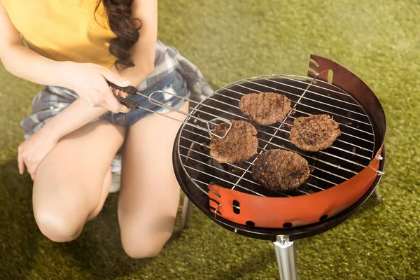 Woman preparing barbecue grill outdoors — Stock Photo, Image