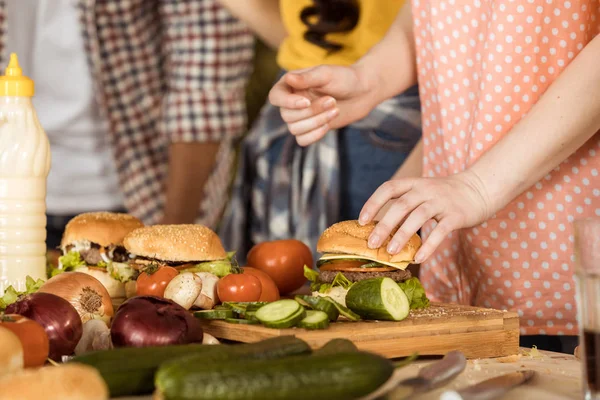 Woman preparing hamburgers on kitchen board — Stock Photo, Image