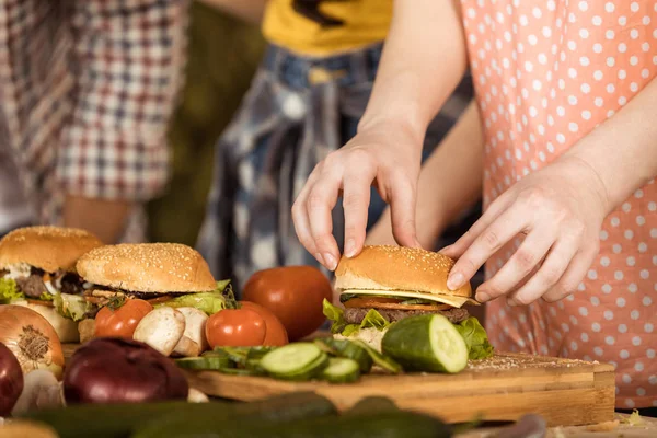 부엌 보드에 햄버거를 준비 하는 여자 — 스톡 사진