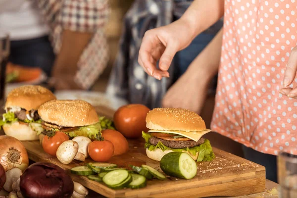 Woman preparing hamburgers on kitchen board — Stock Photo, Image