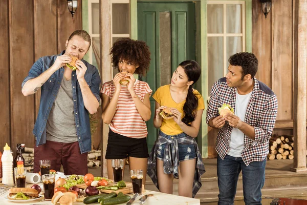 1 multi-etnisch vrienden eten hamburgers op picnic — Stockfoto