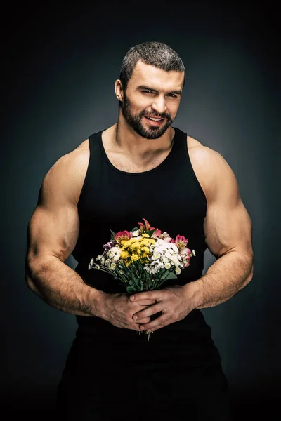 Homem esportivo com buquê de flores — Fotografia de Stock