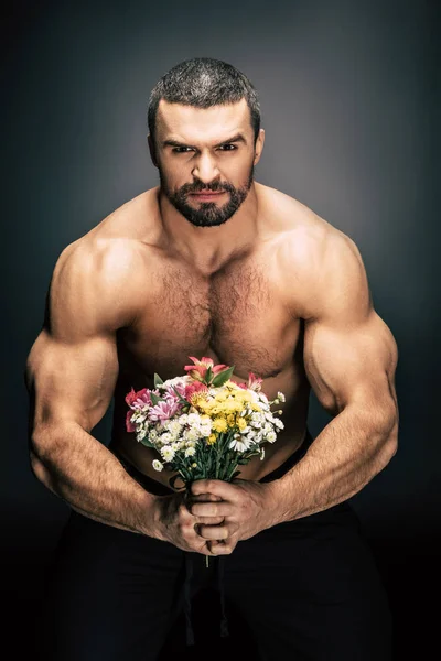 Sportive man with bouquet of flowers — Stock Photo, Image