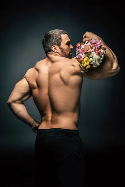 Sportive man with bouquet of flowers — Stock Photo, Image