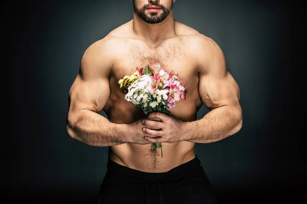 Sportive man with bouquet of flowers — Stock Photo, Image