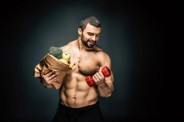 Homem atlético com comida saudável e haltere — Fotografia de Stock
