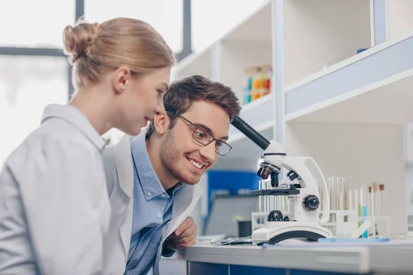 Cientistas que trabalham com microscópio — Fotografia de Stock