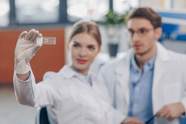 chemists with microscope slide