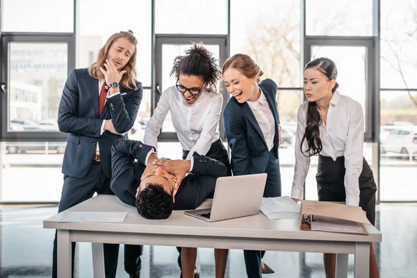 Empresarias castigando a hombre de negocios - foto de stock