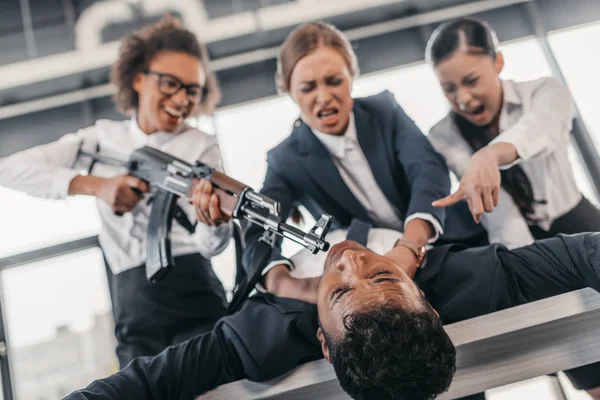 Businesswomen punishing businessman — Stock Photo