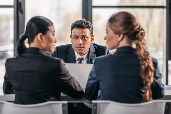 Compañeros de trabajo en ropa formal argumentando en la reunión de negocios - foto de stock