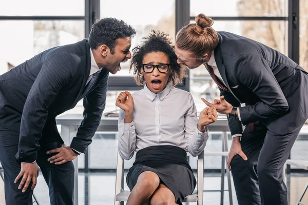 Homens de negócios gritando com empresária no escritório — Fotografia de Stock