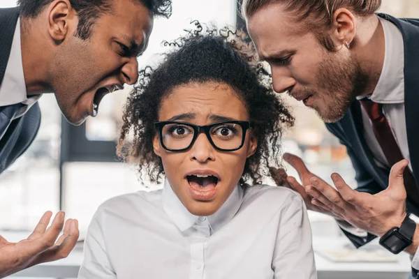 Businessmen screaming on businesswoman in office — Stock Photo