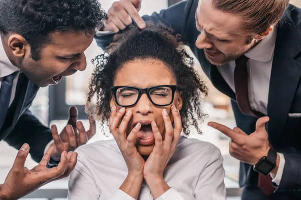 Uomini d'affari urlando sulla donna d'affari in ufficio — Foto stock