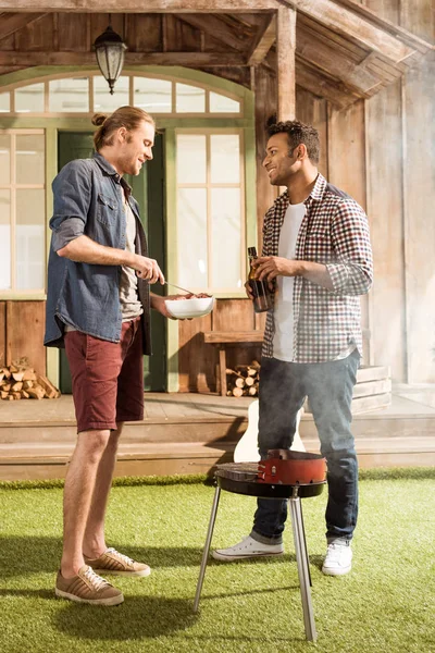 Men grilling burgers — Stock Photo