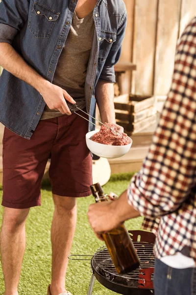 Men grilling burgers — Stock Photo