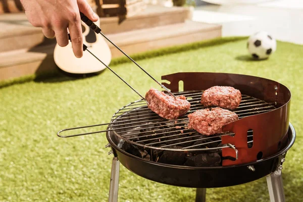 Person grilling burgers — Stock Photo