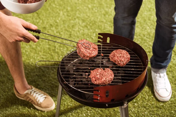 People grilling burgers — Stock Photo