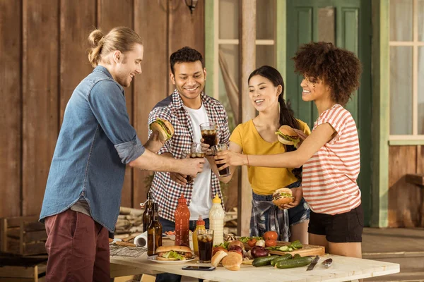 Multiethnische Freunde klirren bei Picknick mit Gläsern — Stockfoto