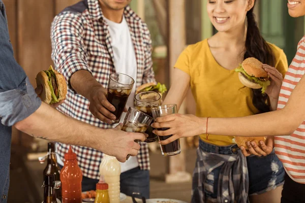 Freunde klirren beim Picknick mit Cola-Gläsern — Stockfoto