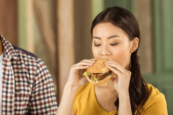 Jovem asiático menina comer hambúrguer — Fotografia de Stock