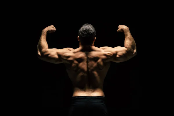 Спортивный мужчина без рубашки показывает мышцы — стоковое фото