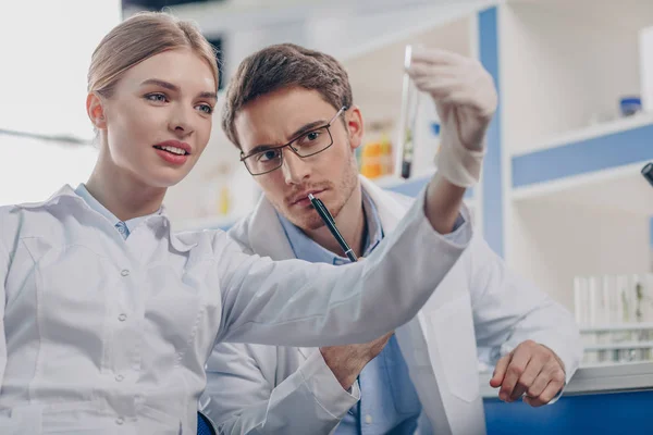 Biologists holding flask with plant — Stock Photo