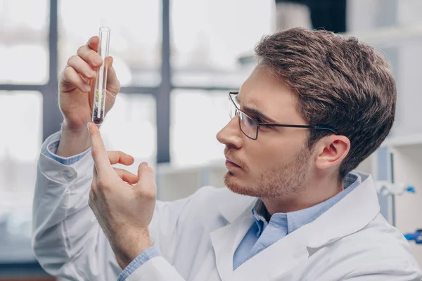 Biologe mit Pflanze im Kolben — Stockfoto